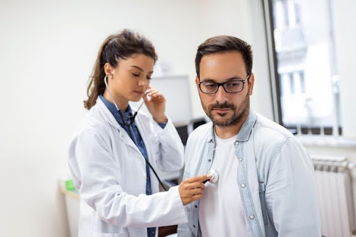 Doctor using a stethoscope to diagnose asthma in a male patient.