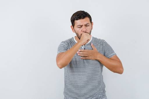 Man experiencing asthma symptoms: coughing and chest discomfort